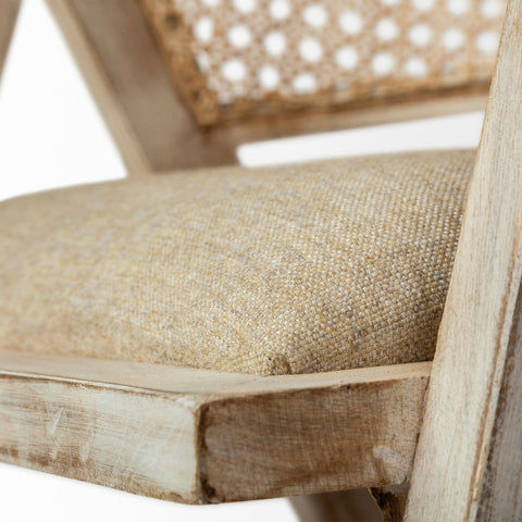 Close-up of a wooden chair with a woven backrest and textured cushion.