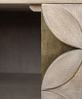 Close-up of a wooden console table with decorative leaf carvings.
