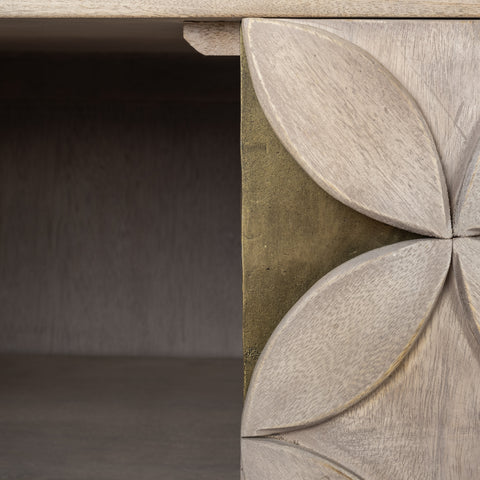 Close-up of a wooden console table with decorative leaf carvings.