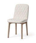 White quilted chair with wooden legs on a white background
