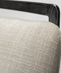 Close-up of a textured beige cushion on a chair with a metallic frame.