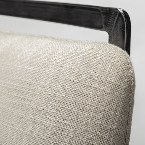 Close-up of a textured beige cushion on a chair with a metallic frame.
