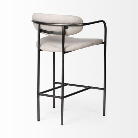 Bar stool with black metal frame and beige cushioned seat on a white background