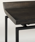 Dark wooden table with black metal legs on a light gray background