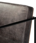 Close-up of a gray upholstered chair with black metal frame on a white background