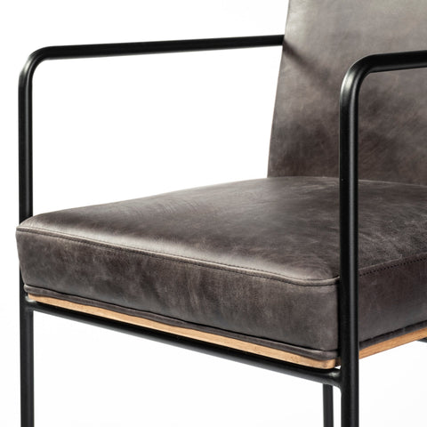 Gray upholstered chair with black metal frame on a white background