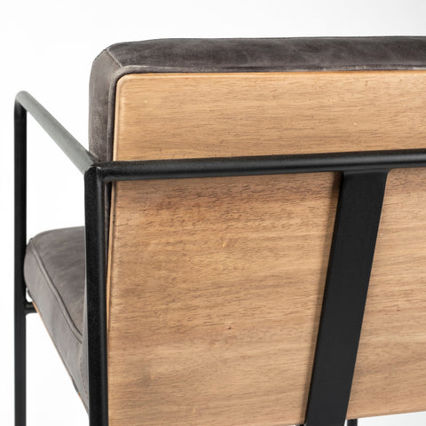 Close-up of a wooden chair with black metal frame and gray cushion.