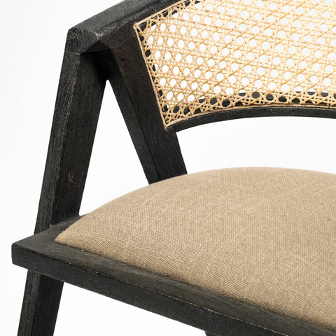 Close-up of a chair with black frame, beige woven backrest, and beige cushion on a white background