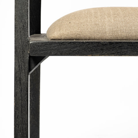 Close-up of a chair with a wooden frame and beige cushion on a white background