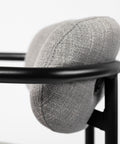 Gray textured cushion on a black metal stool against a white background