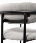 Gray upholstered chair with black metal frame on a white background