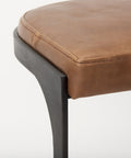 Brown leather stool with a black metal frame on a white background