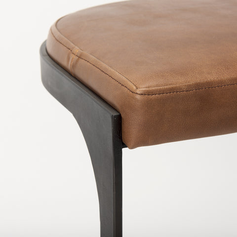 Brown leather stool with a black metal frame on a white background