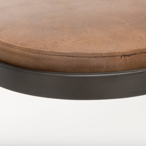 Close-up of a brown leather stool with a metal base on a white background
