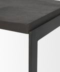Close-up of a black metal table corner with a gray surface.