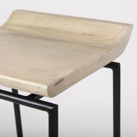 Wooden stool with black metal legs on a light gray background