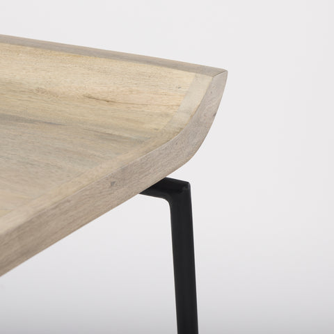 Close-up of a wooden table with a black metal leg on a white background