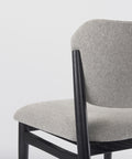 Gray upholstered chair with black metal frame on a light gray background
