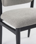 Gray upholstered chair with black frame on a white background