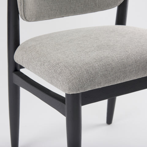 Gray upholstered chair with black frame on a white background