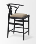 Black bar stool with a beige cushion on a white background
