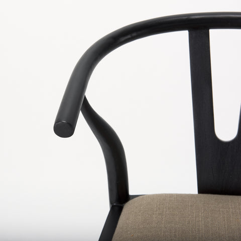 Close-up of a black chair arm and seat on a white background