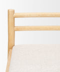 Close-up of a wooden chair with a white cushion on a light gray background
