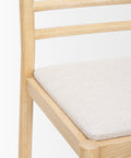 Wooden chair with a white cushion on a white background
