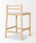 Wooden bar stool with a white cushion on a light gray background