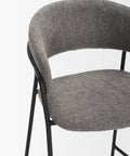 Gray upholstered chair with black metal frame on a white background