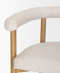 Close-up of a chair with beige fabric seat and backrest on a white background