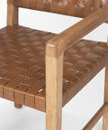 Brown woven chair with wooden frame on a white background