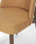 Close-up of a brown leather chair with wooden legs on a white background