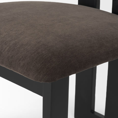 Close-up of a brown upholstered chair seat with black legs on a white background