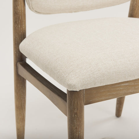 Close-up of a wooden chair with beige cushioned seat and backrest on a light background