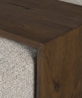 Close-up of a wooden surface with a textured gray carpet corner.