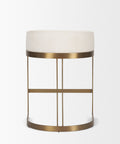 Small round table with a white cushioned top and gold metal frame on a light gray background