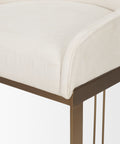 Close-up of a chair with a white cushioned seat and bronze frame on a light background