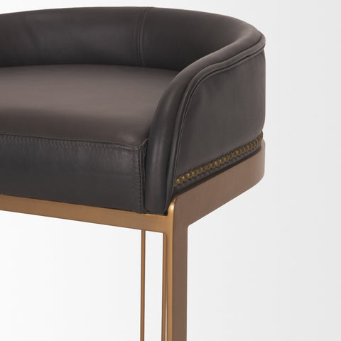 Close-up of a black leather chair with gold legs on a white background