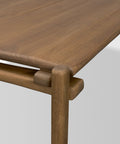 Close-up of a wooden table with a light brown finish on a white background