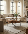 Cozy living room with a stone fireplace, beige sofa, and wooden coffee table.