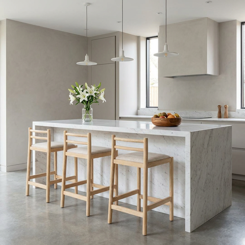 Modern kitchen with a marble island and wooden stools.