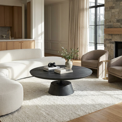 Modern living room with white sofa, black coffee table, and beige armchairs.