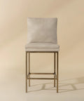 Beige bar stool with cushioned seat and backrest on a beige background