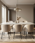 Modern dining room with a marble table and beige chairs.
