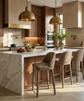 Modern kitchen with marble island, wooden cabinets, and brass pendant lights.