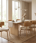 Dining room with wooden table and chairs in a bright room.