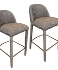 Two gray bar stools with textured seats and metal legs on a white background