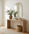 Wooden console table with decorative items against a white wall