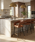 Modern kitchen with marble island, wooden cabinets, and brass pendant lights.